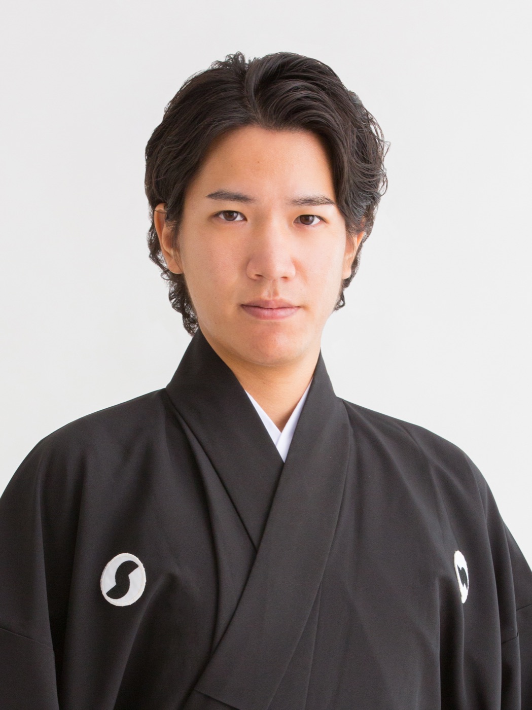 紋付の黒い着物姿で正面を向く仲嶺良盛の肖像